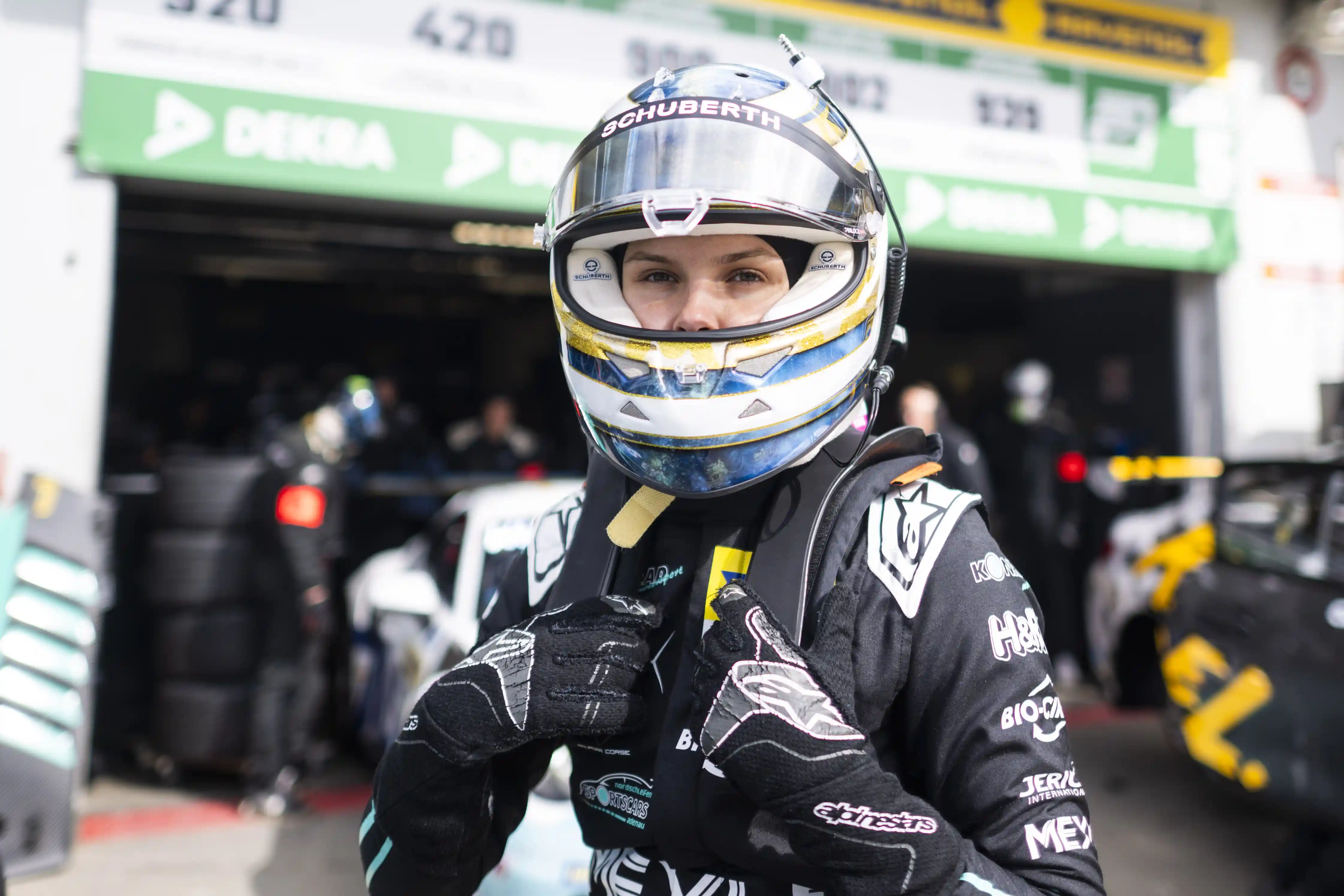 女车手佩戴蓝金涂装 Schuberth 头盔，调整装备准备上场